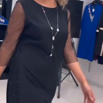 Egy testhezálló ruha oldalsó hasítékokkal és flitteres csipkével